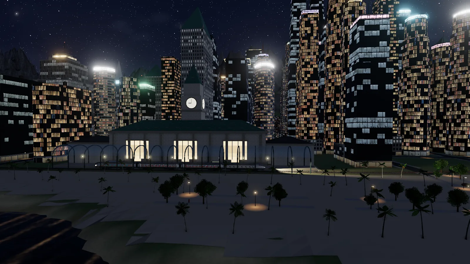 Calder Union at night: a limestone terminal with a lit clock tower and a glass train shed, surrounded by towers full of lit windows.