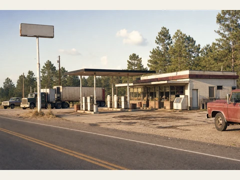 The roadside truck stop, with fuel pumps and a low diner.