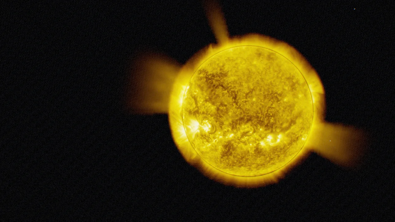 The Sun in gold extreme-ultraviolet light with bright coronal loops over active regions and dark coronal holes.