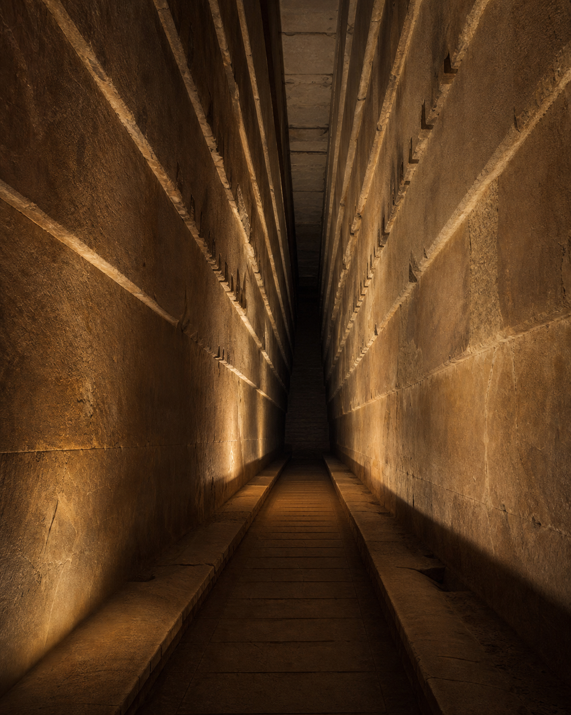 A warm-lit reconstruction of Khufu's Grand Gallery, showing its tall corbelled walls and central passage