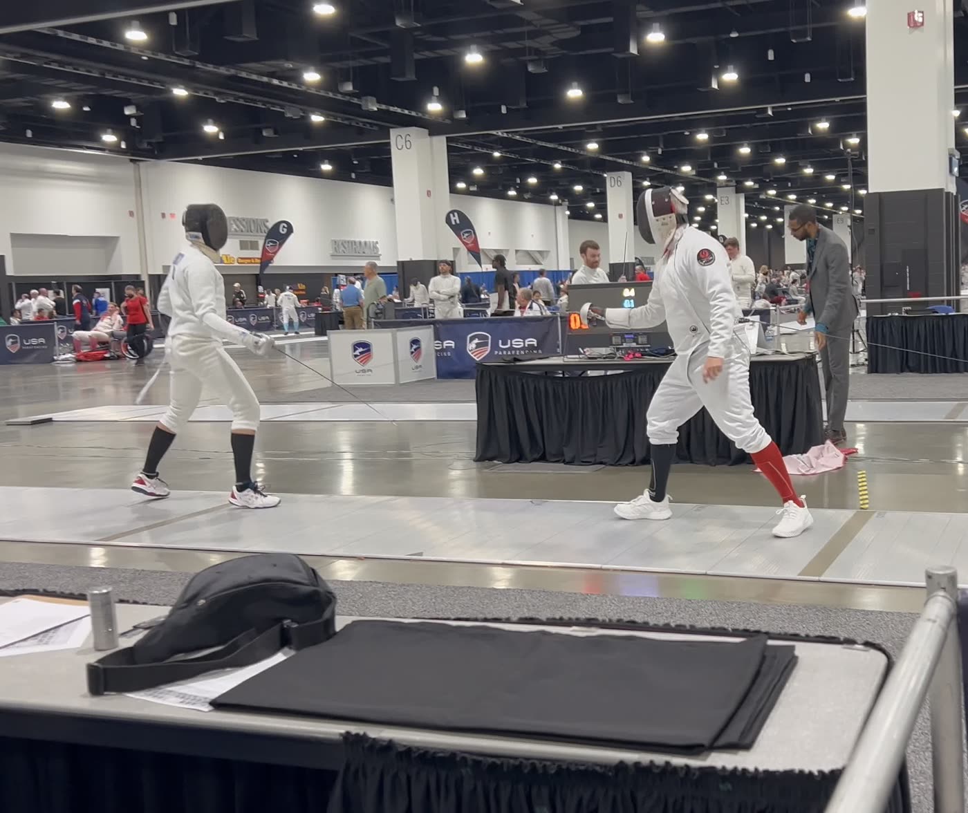 Eric Rhea testing an opponent on the strip at a USA Fencing national convention-center venue